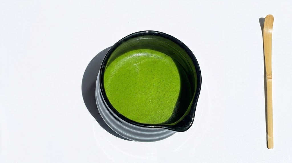 Ceremonial matcha being whisked into a smooth, frothy bowl